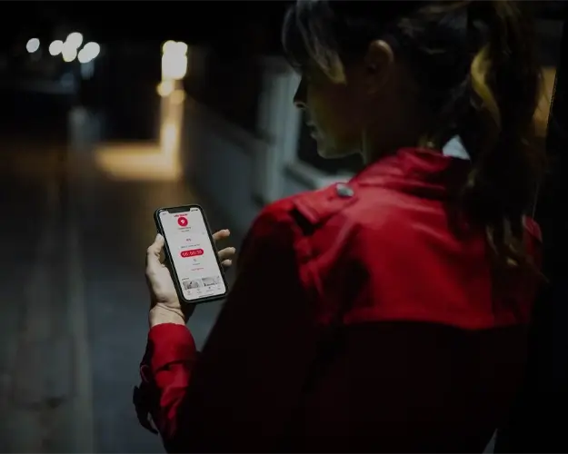 Person i mørket med verisure guardian på mobilen Person i mørket med verisure guardian på mobilen